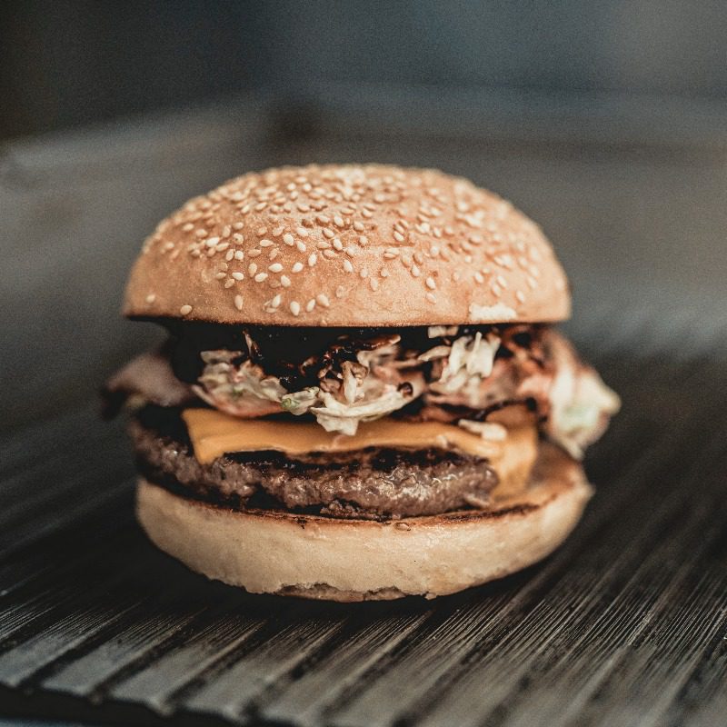 beef burger with sesame bun, cheese and greens